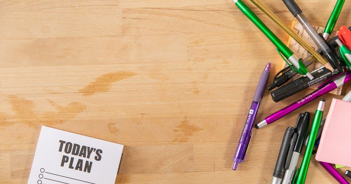 A notepad marked “Today’s Plan” with pens on a wooden desk.