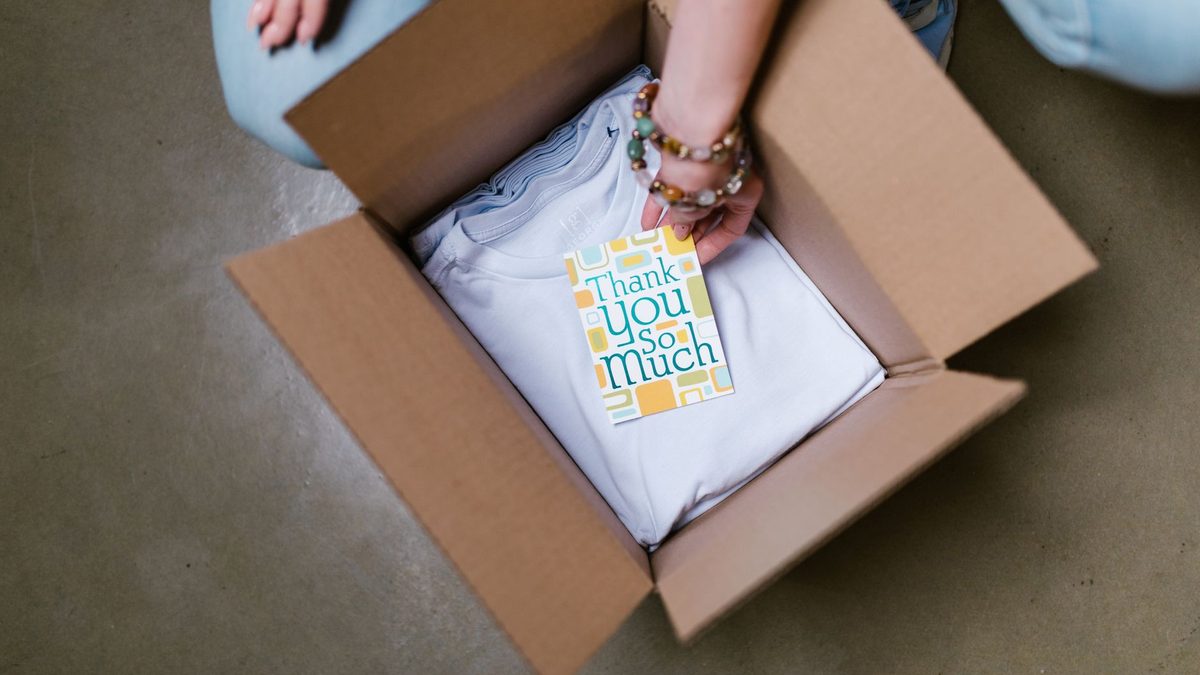 A person packing a product into a cardboard box.