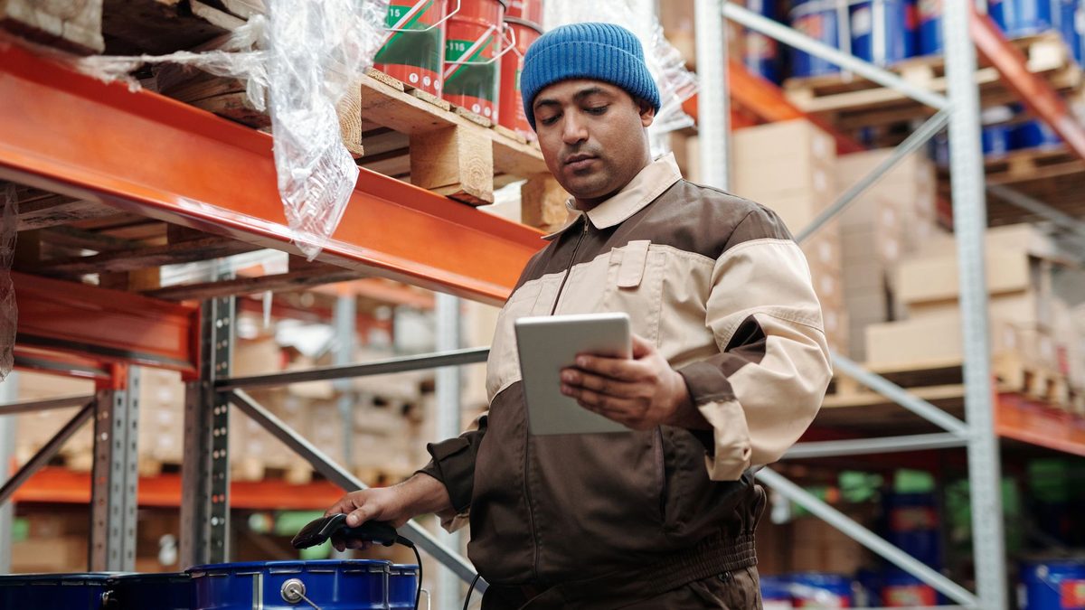 A warehouse worker using a tablet for inventory.